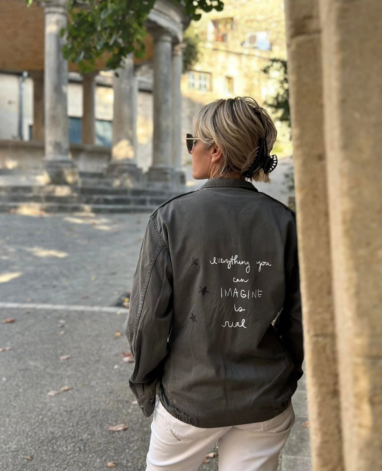 Veste femme personnalisée portée de dos en extérieur dans un style mode créateur.