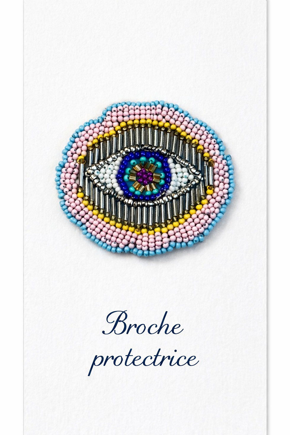 Texte ALT : Pin’s broche œil protecteur perlé de 6 cm avec dos cuir, broderie de perles roses, bleues, blanches et dorées sur