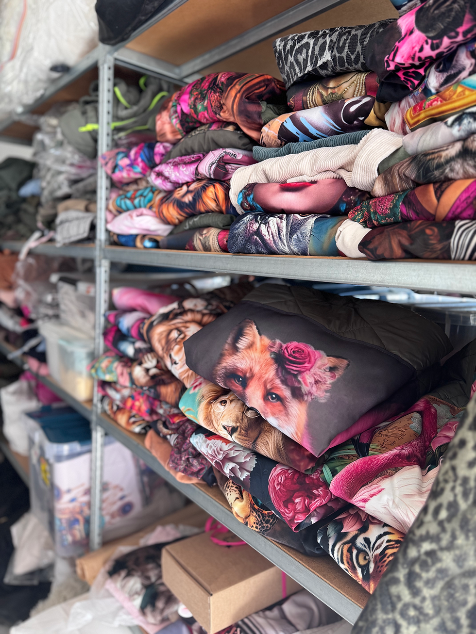 Étagères remplies de tissus imprimés colorés pour créations textiles et vêtements personnalisés.