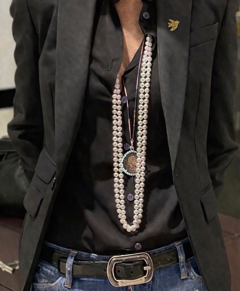 Pin’s colombe pailletée dorée en résine porté sur le revers d’un blazer noir