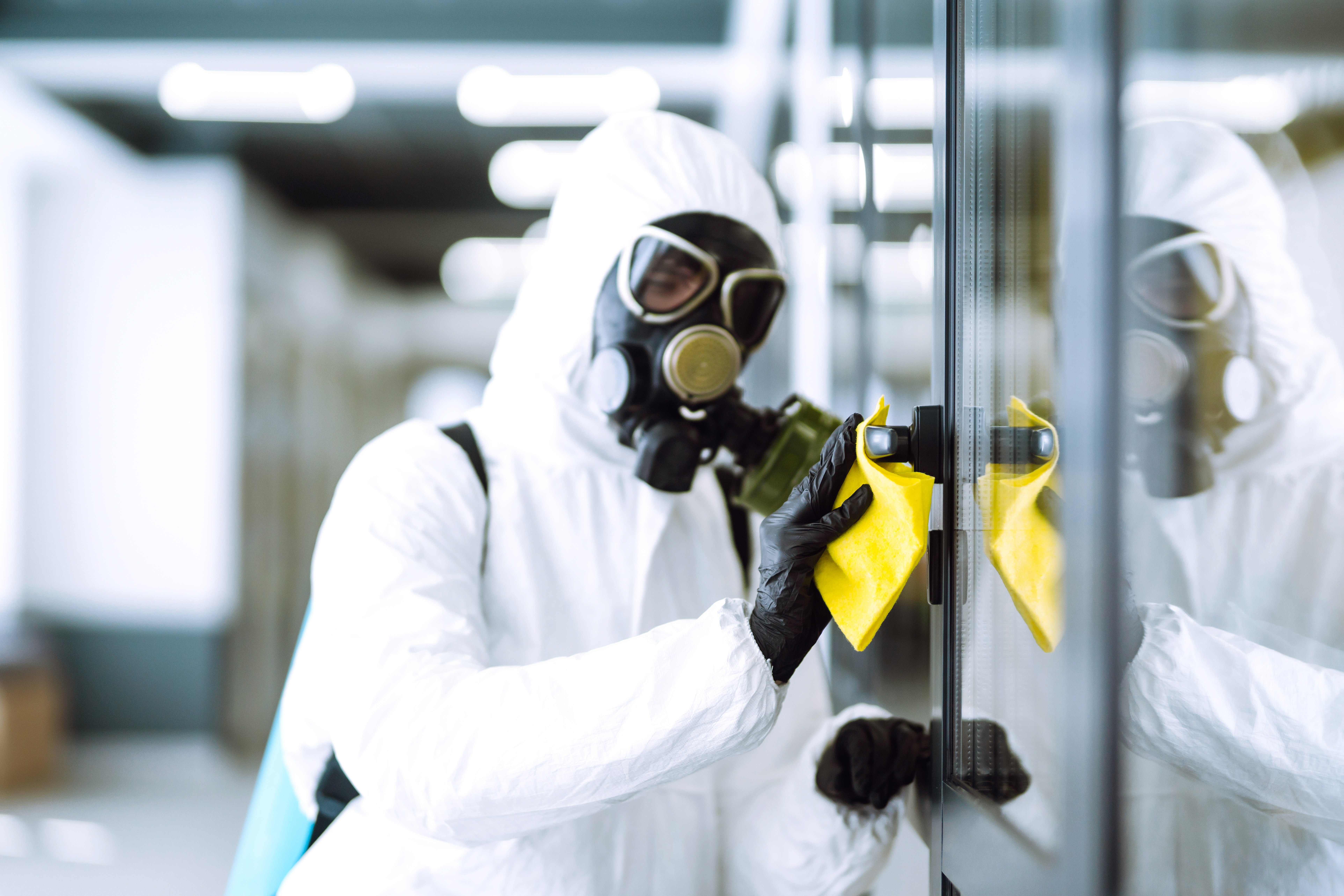 worker-in-protective-suit-cleans-glass-door-2026-03-19-22-05-28-utc.jpg