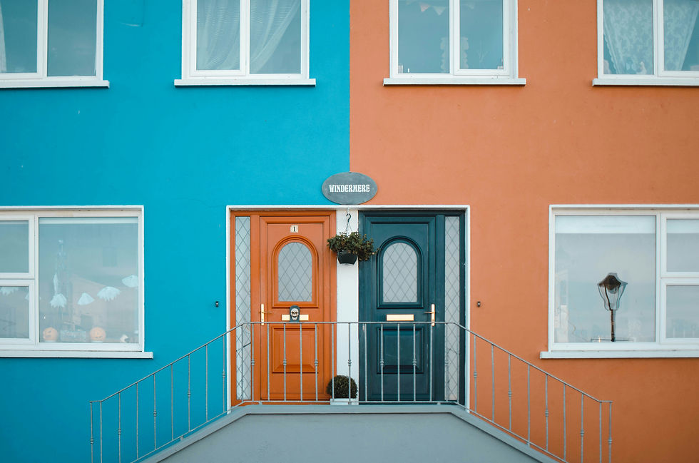 A building with two doors. Each side is oppositely colored in turquoise and orange.