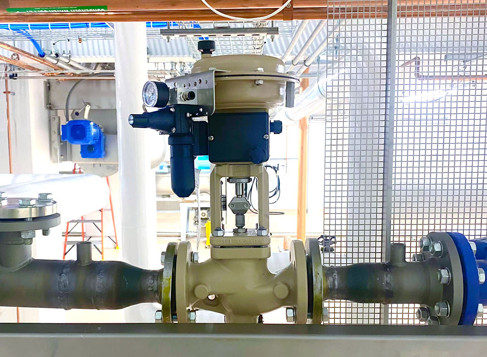A pneumatic control valve with positioner mounted on an industrial process pipeline inside a production facility.