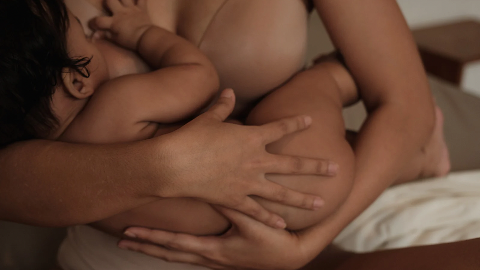 mother holding baby while breastfeeding