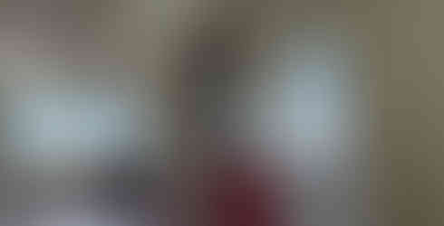 ViTrox College student climbs on a ladder to clean the ceiling fan in the community hall of the home.