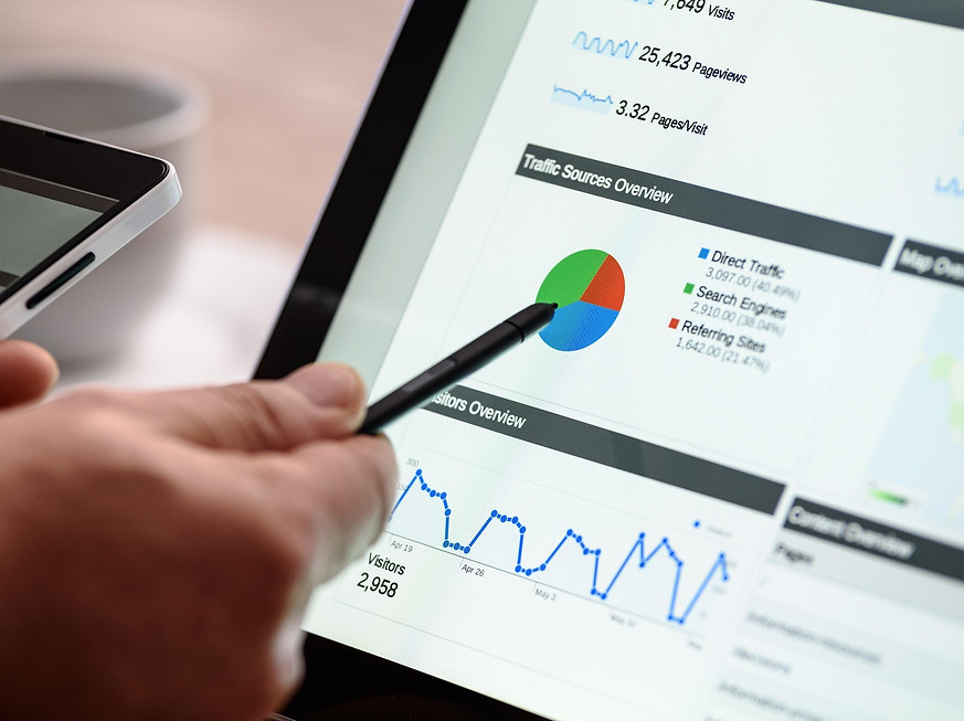 Person zeigt auf digitales Marketing-Dashboard mit Analysekurve – Symbol für Online-Marketing und SEO-Optimierung