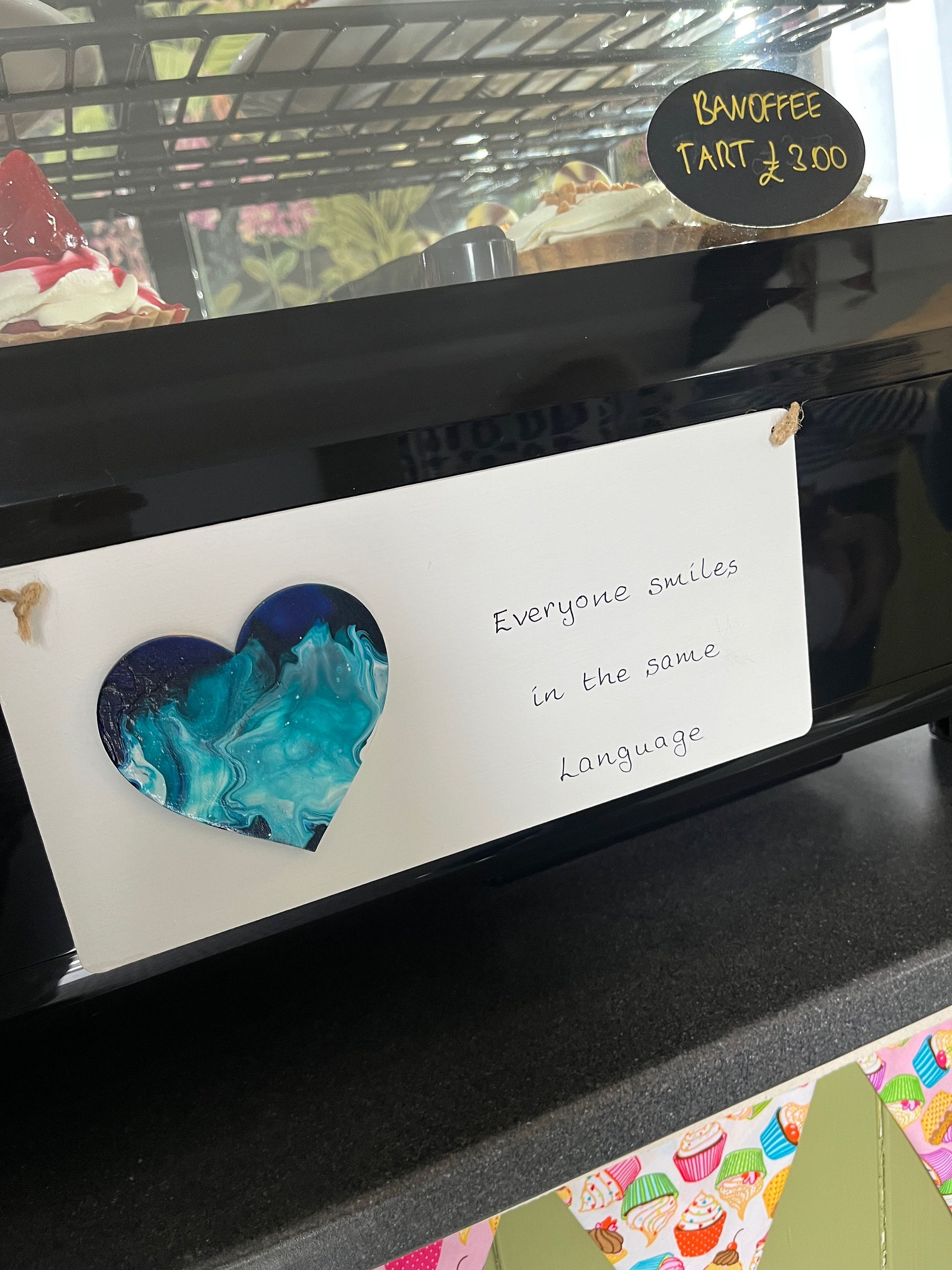 Decorative sign inside Sidings Café reading “Everyone smiles in the same language,” highlighting the café’s welcoming atmosphere.