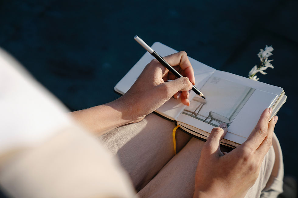person drawing in notebook on lap