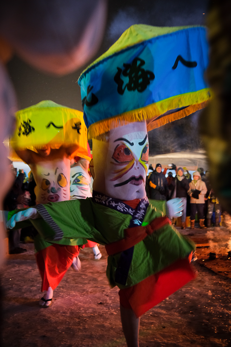 a group of people wearing colorful costumes with Japanese writing on them