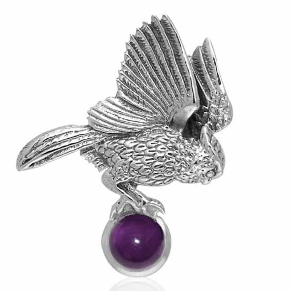 Silver bird with detailed raised wings holding a spherical purple gemstone.