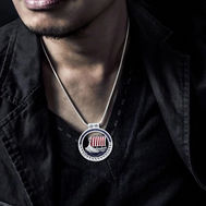 Person wearing a silver pendant necklace with a Viking longship design.