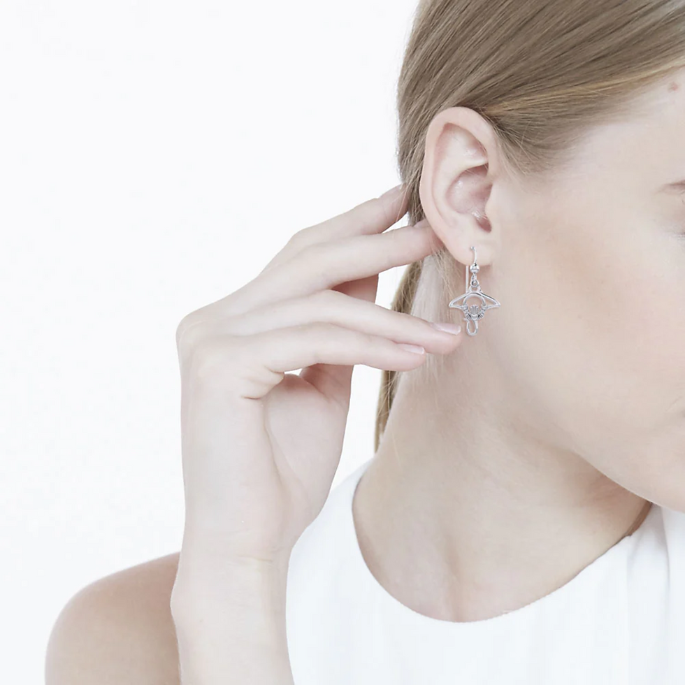 Thumbnail: Woman wearing ornate silver dangle earring, hand gently touching her ear.