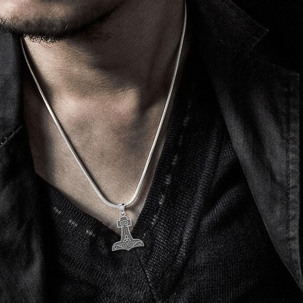 Thumbnail: Man wearing a detailed Thor's Hammer pendant on a white cord over dark shirt.