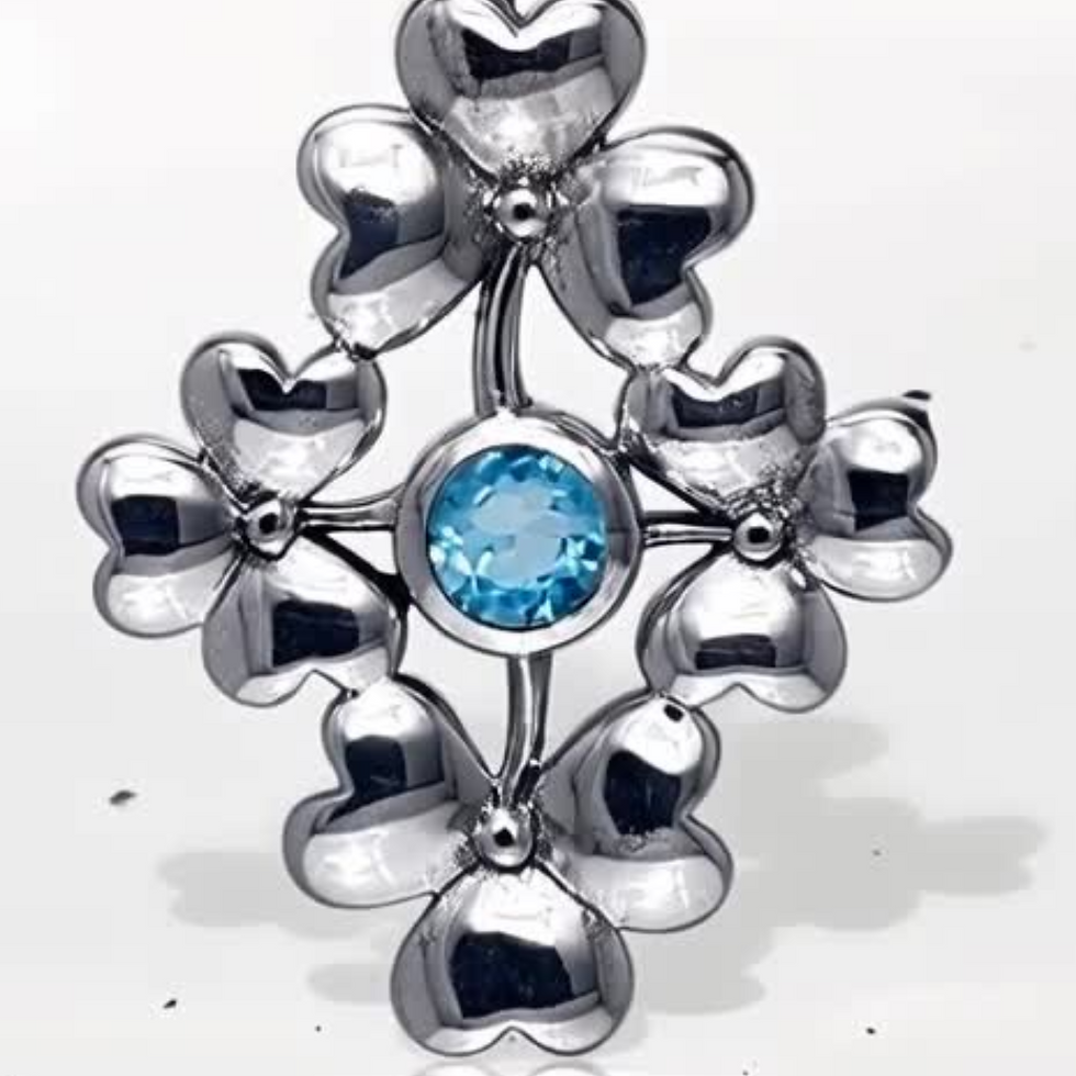Thumbnail: Silver pendant with blue gemstone, shaped like a flowery cross.