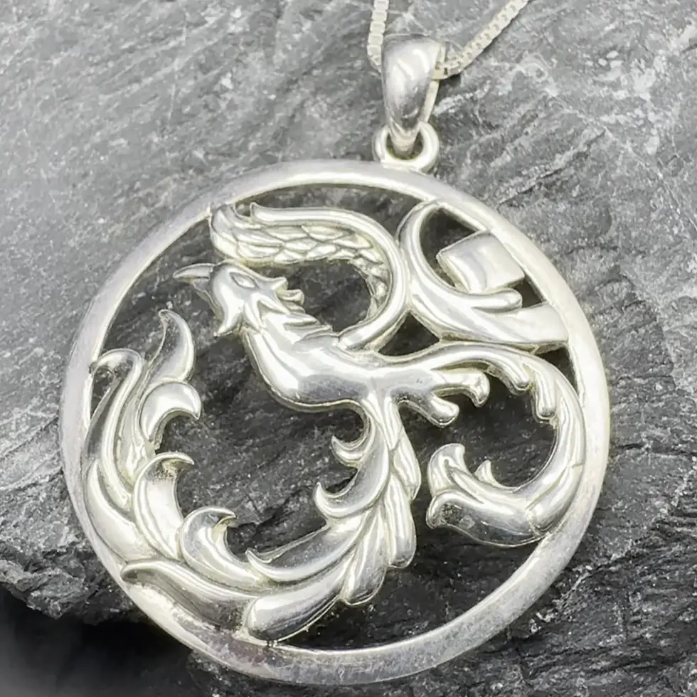 Thumbnail: Silver pendant features intricate mythical bird and ornate scrolling on dark stone.