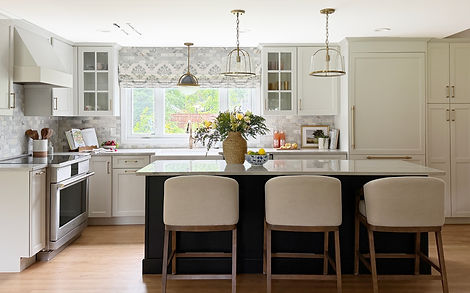 Avon kitchen with white cabinetry, a black island and stone countertops.