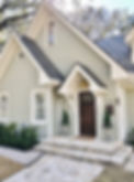 A house featuring gray siding, white trim, and a prominent brown front door.