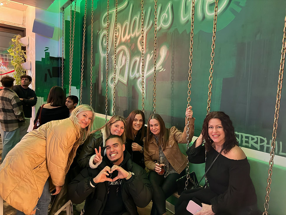 Eye-level view of a host holding a camera while capturing a group of guests enjoying a lively outdoor bar