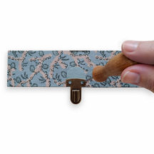 Utilisation d'un poinçon pour percer le couvercle d'un cartonnage pour fixer un fermoir tuck