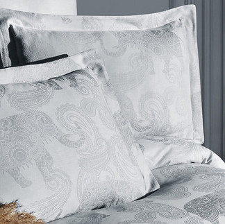 Luksusowa biała pościel z adamaszku o pasmowym splocie, zapewniająca naturalną termoregulację i zdrowy sen.