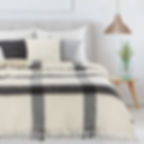 Czarny koc moherowy Eurofirany 130x170 cm rozłożony na łóżku, widoczne frędzle i kratkowy wzór