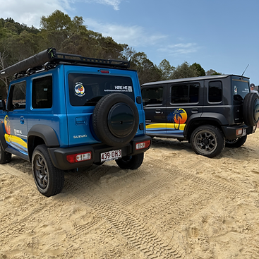 Grey 5-door Suzuki Jimny and blue 3-door Suzuki Jimny parked on Moreton Island Beach at Tangalooma Wrecks
