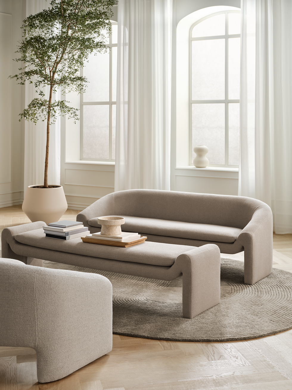 Modern beige living room with sofa, coffee table, and area rug.