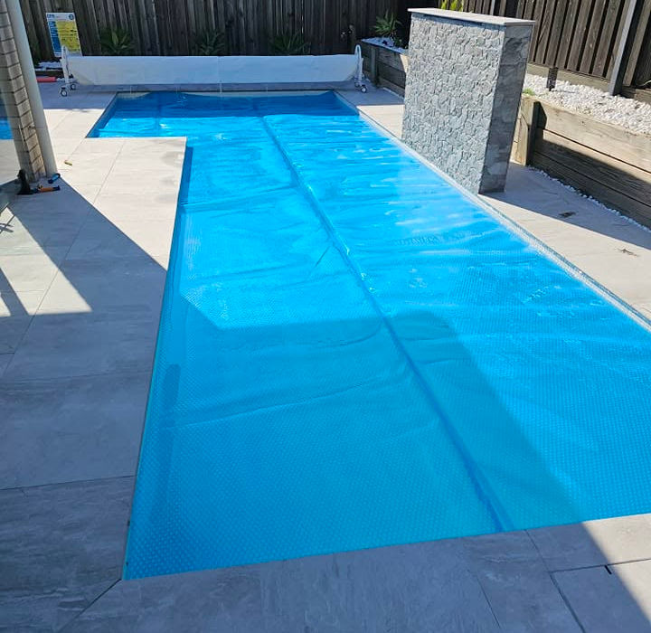 Blue solar cover on an outdoor swimming pool