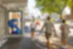 Digital signage displaying a fashion ad at a bus stop.