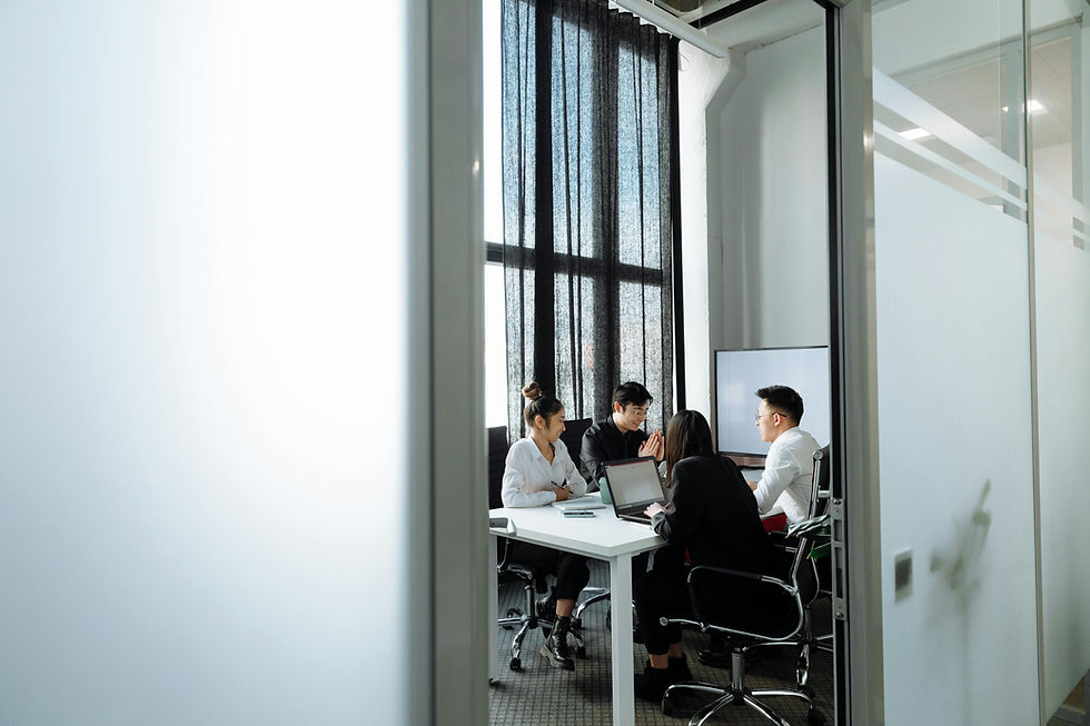 Four professionals collaborating in a modern office meeting room.