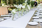 White floral centerpieces on a long outdoor dining table decorated by That Special Event