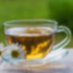Chamomile tea in a cup representing Ayurvedic evening rituals for relaxation and cooling the body.