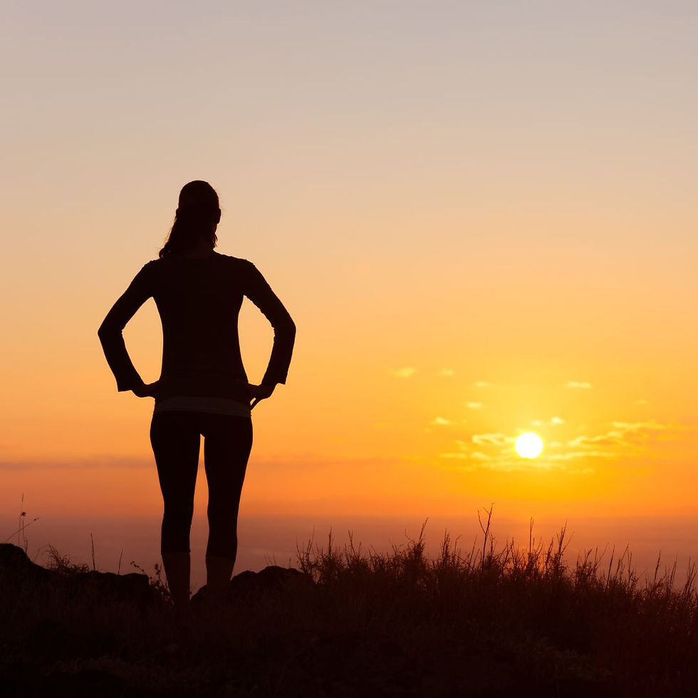 Silhouette of a survivor standing strong against a rising sun, symbolizing hope and resilience