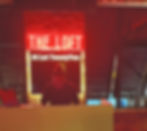 Club, bar, and restaurant near the Colony Infinitum where a DJ is performing under a neon sign reading "THE LOFT at Lot TwentyTwo." The dimly lit room has a vibrant red and cozy ambiance.
