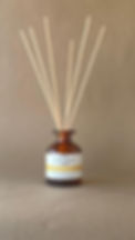 a Willow & Hawthorn Cloudy Lemonade Reed difuser with reeds splayed in the amber glass bottle