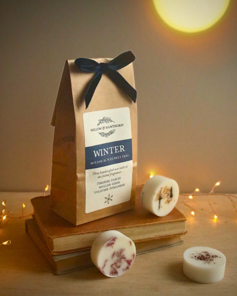Winter Botanical Wax Melt Gift Bag, Kraft paper bag, dark blue velvet bow, showing three individual botanical wax melts