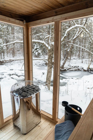 Sauna in the winter overlooking a brook.