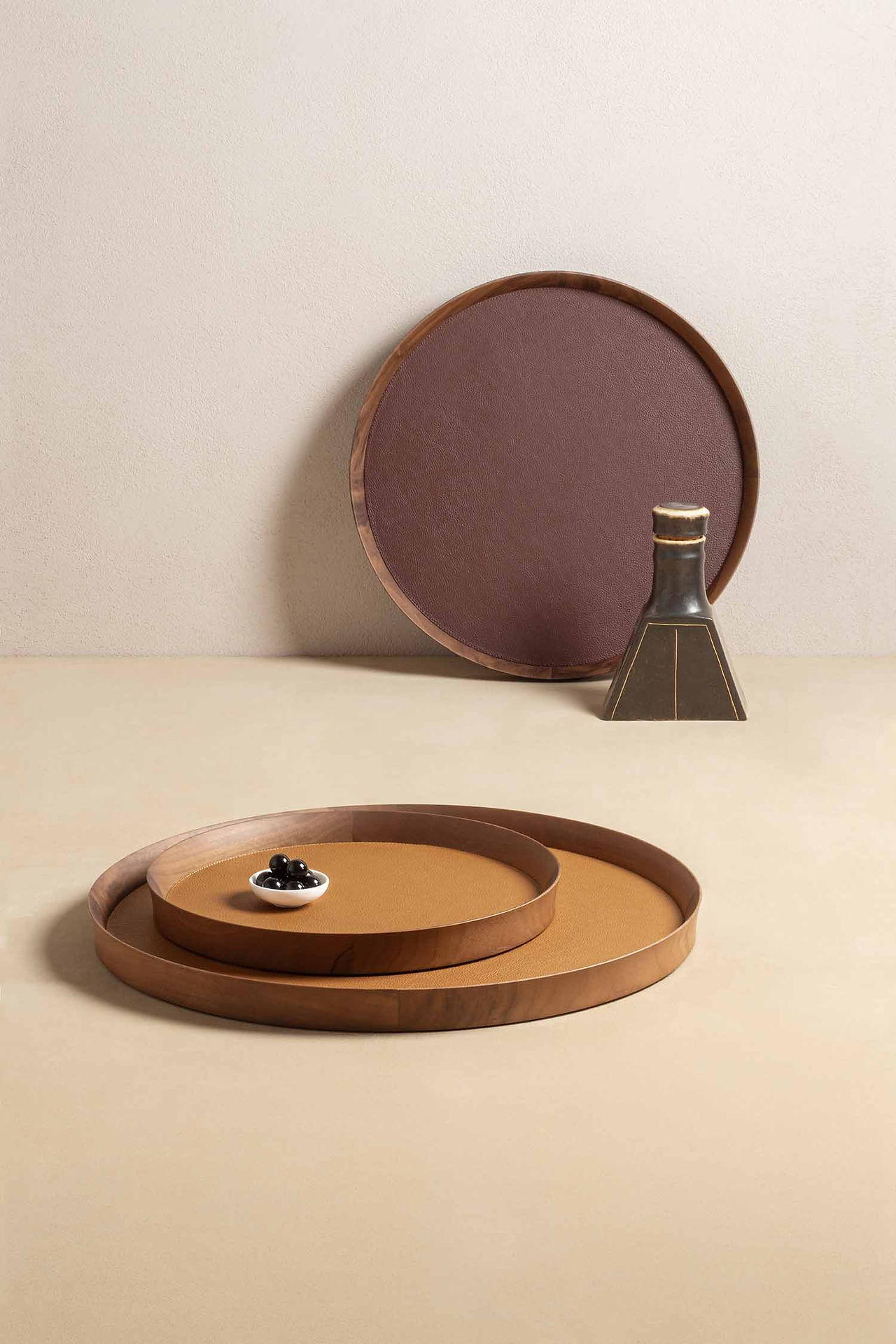 Round tray in the Giobagnara x Poltrona Frau collection, crafted in walnut and Pelle Frau leather