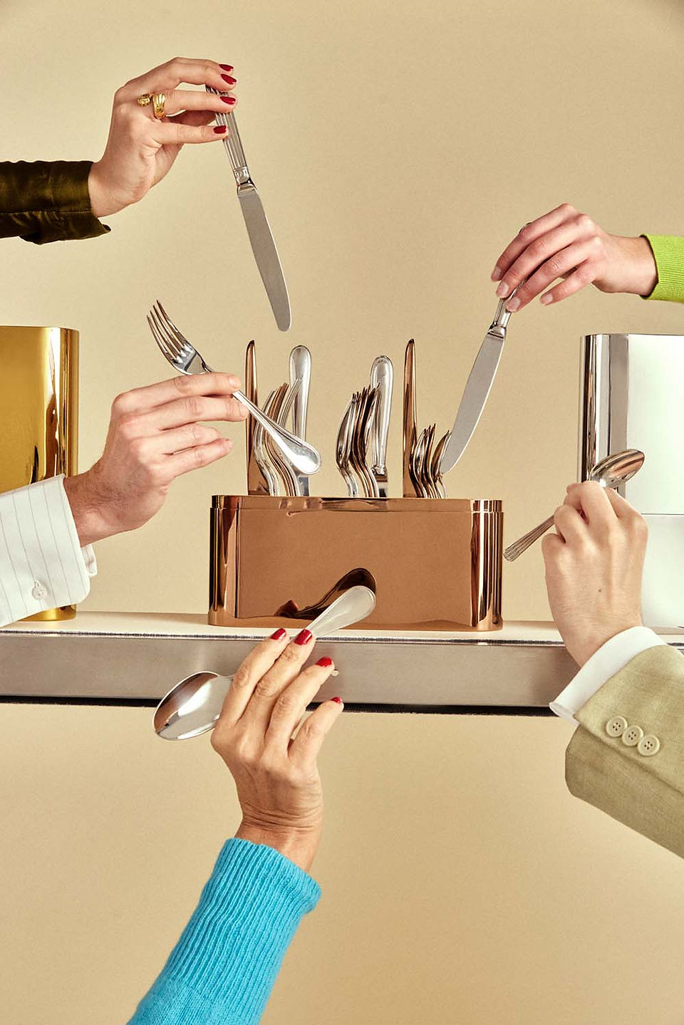 Christofle Concorde cutlery case in rose gold shown with a mixture of Christofle cutlery pieces in silver and rose golf PVD finishes