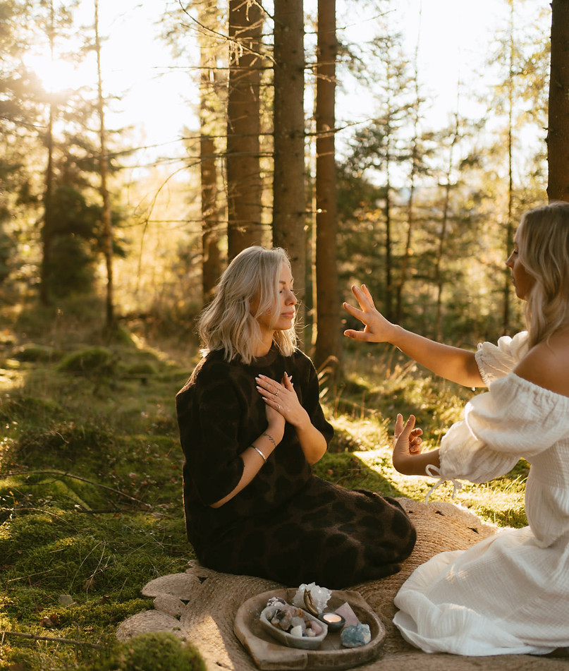 en kvinna som healar en annan kvinna i skogen