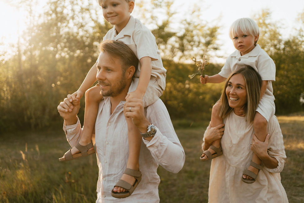 barn sitter på föräldrars axlar ute i naturen