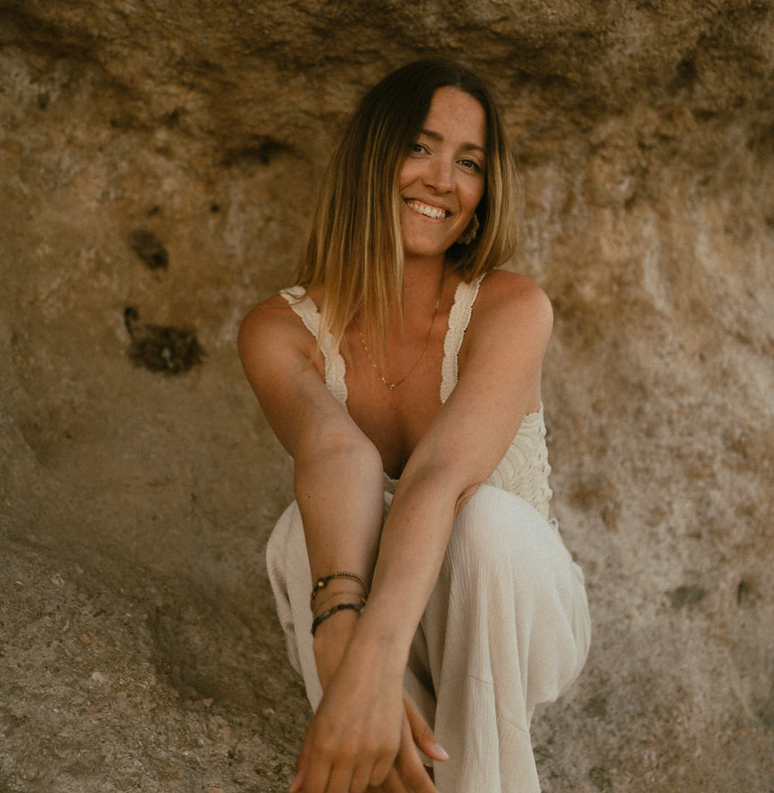 kvinna sitter vid klippor