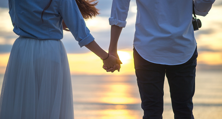 couples hand sunrise beach.png