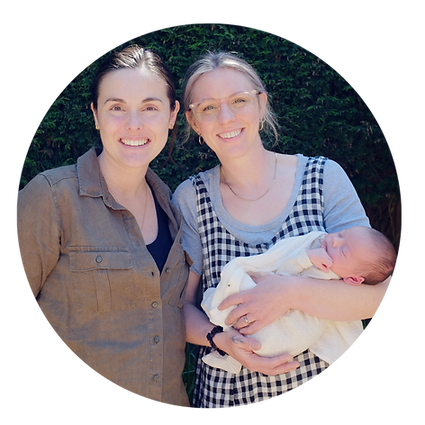 Two women,one in glases holding a newborn in a white blanket both are smiling