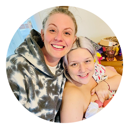 doula and her client both smiling with a newborn