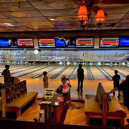 Bowling lanes inside Champion Lanes bowling alley with pins set and seating area for players.