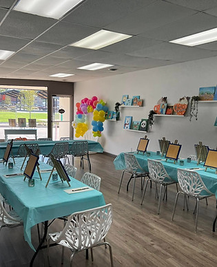 An image of Laurie Arnold Art's studio, including 2 tables and chairs.