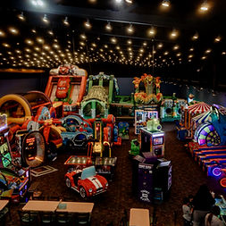 Kids playing on inflatable bounce houses and indoor play structures at Jump N Jax family entertainment center.