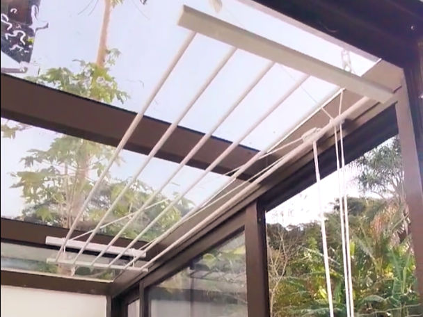 Varal tradicional de teto branco com 6 varetas na área externa