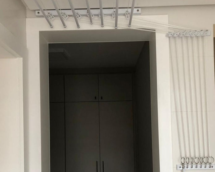 Comando de um varal individual de 7 varetas instalado no lado da porta e varal está acima da porta